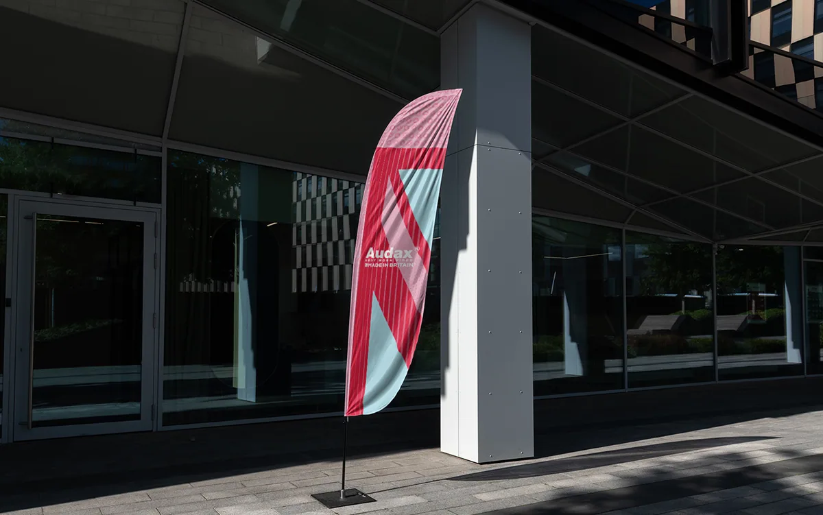 Audax branded feather flag outside a commercial building